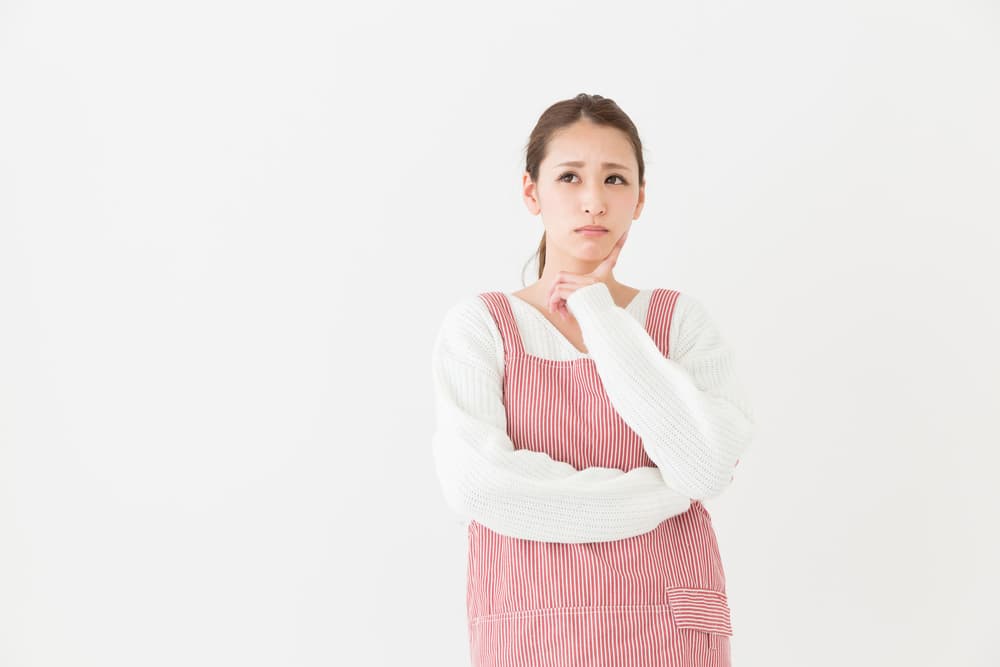 腕を組んで深刻そうに悩む女性