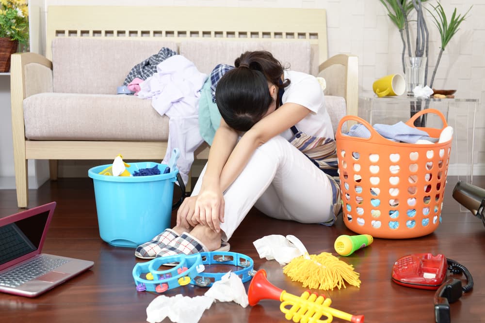 散らかった部屋で座り込む女性