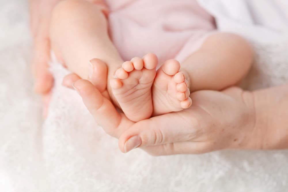 赤ちゃんの足と、女性の手