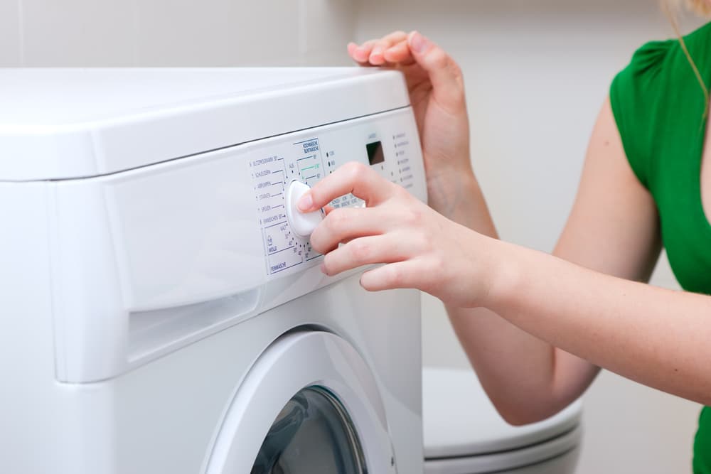 洗濯機の洗濯コースを指定している女性の手元