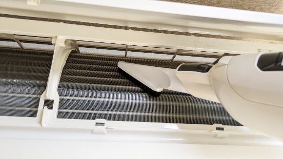 ファンについたホコリを掃除機で吸い取る