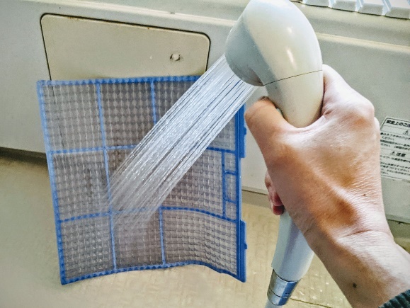 ホコリがついていない側(裏側)からシャワーをあてて、水洗いをする