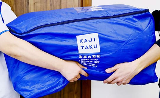 専用回収袋に入れた羽毛布団を集荷する様子