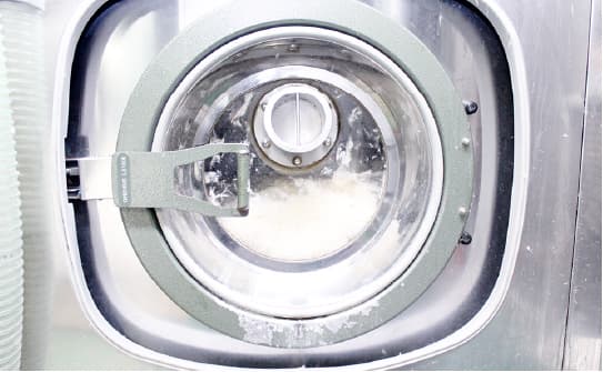 専用機器で羽毛を洗浄して除塵する工程